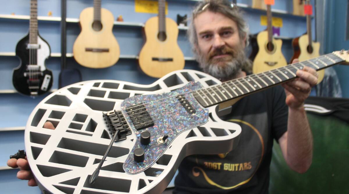 READY TO ROCK: 3DGT Guitars owner Nathan Hughston holds a guitar he designed that was made with his 3D printing technology. 