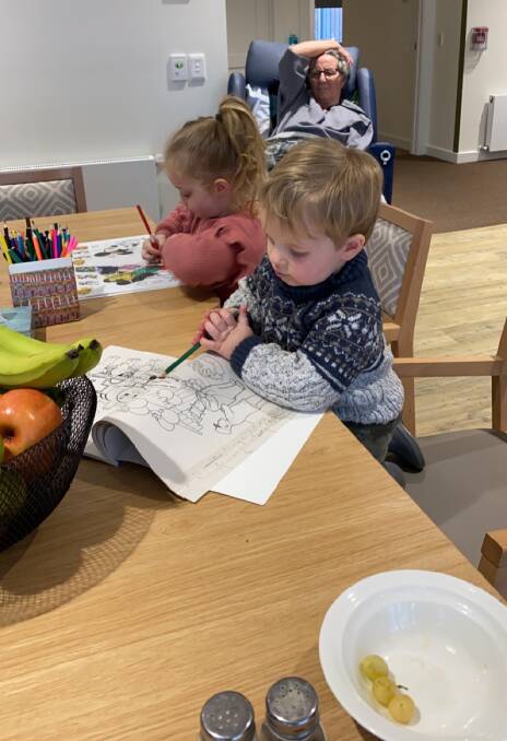 FAMILY TIME: Harriet and Rupert can still spend time with their grandmother colouring in and eating snacks at the dining table in Mercy Place.