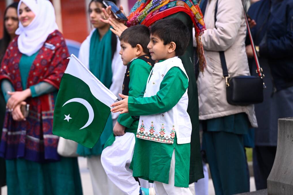 Rayayn waves a Pakistani flag for the flag-raising ceremony. Picture by Adam Trafford
