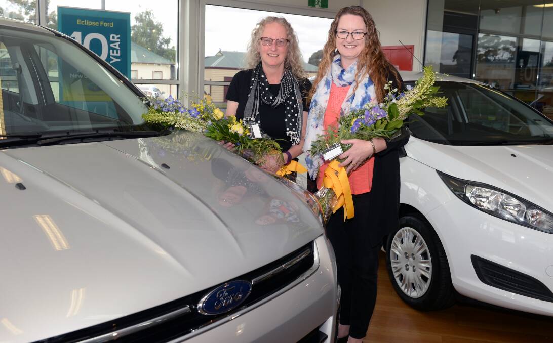 SMILES: Rotary raffle winner Kate Perkins with her new Ford Kuga and runner-up Louise Varsaci with her Ford Fiesta to take home from Ballarat. Picture: Kate Healy