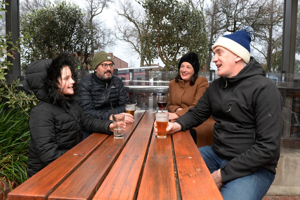 RUGGING UP: Florence with Luke Dunne, Kate Davis and Dan Cronin embrace the Ballarat cold to catch up over a drink in the beer garden earlier this week. Picture: Kate Healy
