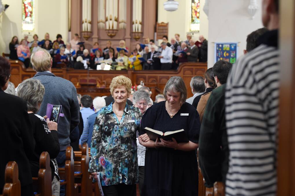 Congregation members Sue Nicholls and Laurenne Robertson lead the final procession out from Neil Street Uniting Church on Sunday morning. Picture by Kate Healy