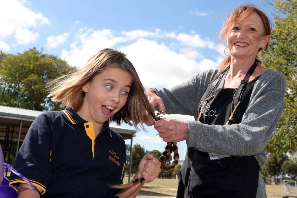 CHANGE: Sienna McLure, 11 with Veronica Moschetti (Clunes Hairdressers). Sienna McLure is cutting her hair for Shannon's Bridge and this was pulled forward because of unexpected early end of school. Picture: Kate Healy