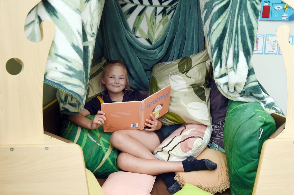 SETTLING IN: Phoenix pupil Mikaela finds a comfy way to start her school day in the Nurture Room program, helping pupils who find the transition from home to school a challenge. Picture: Kate Healy