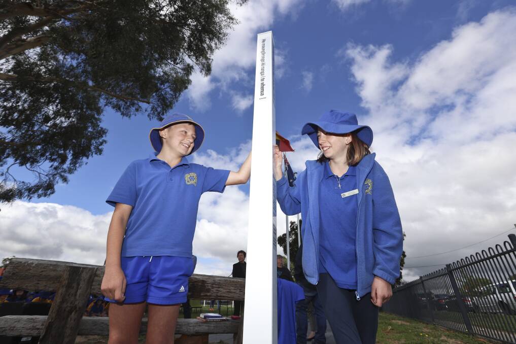 Sebastopol primary pupils Seth and Alexis with the peace poles, which feature the phrase of 'may peace prevail' in Ukrainian, Maori, English and Wadawurrung languages. Picture by Luke Hemer