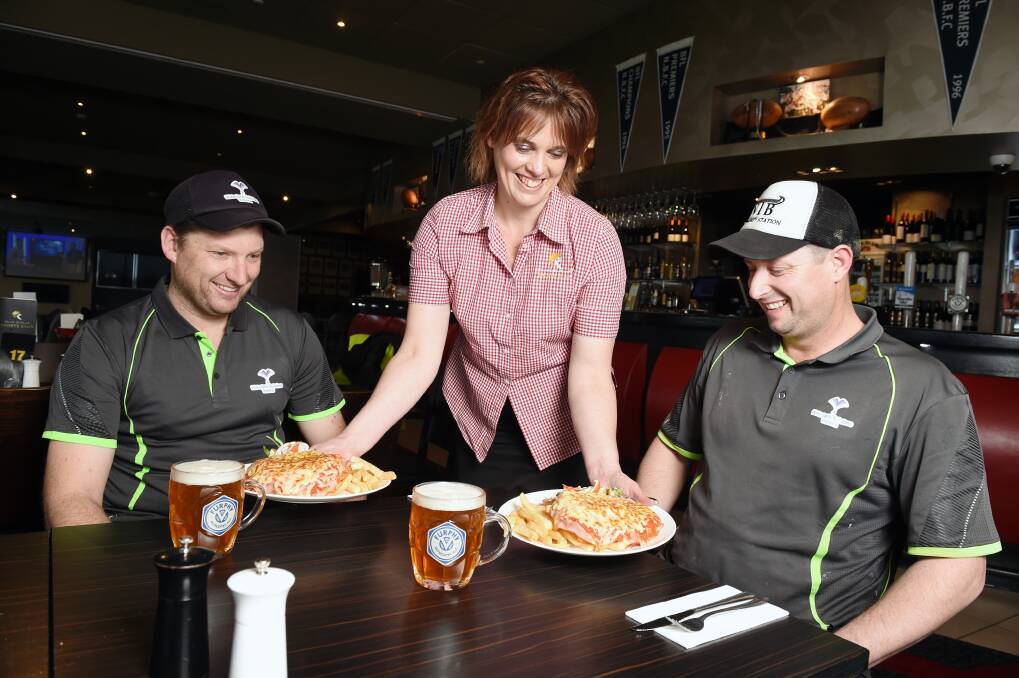 EAT FOR A CAUSE: North Ballarat Sports Club's Michelle Gladman serves up parmas to Justin Rumble and Damien Garvie help farmers in drought. Picture: Kate Healy