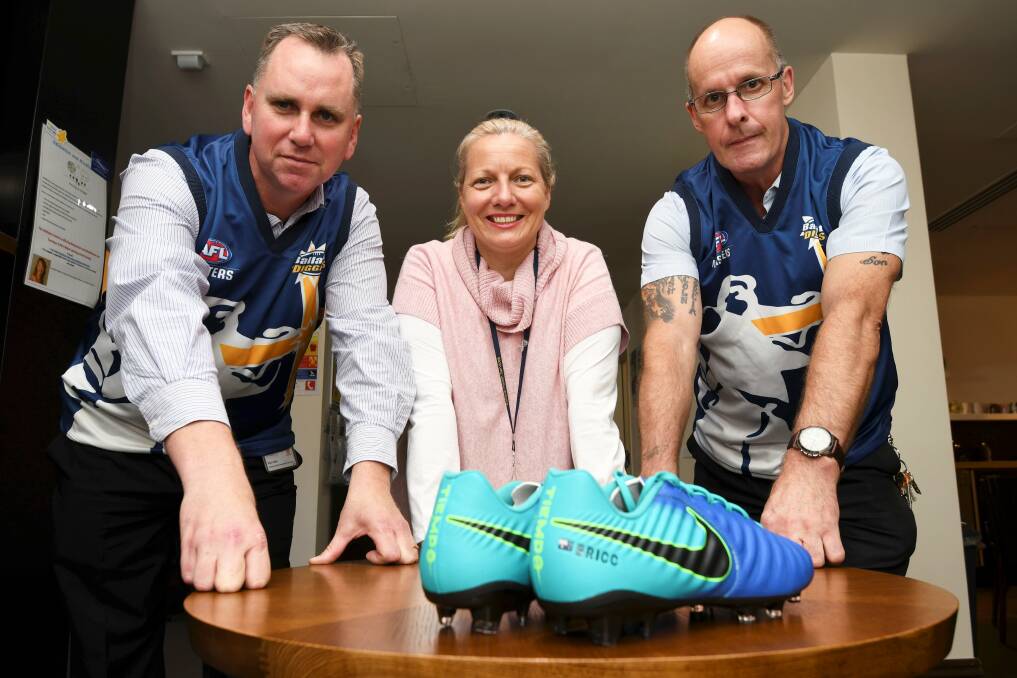 KEY GOAL: Ballarat Masters footballers Rod Lewis and Noel Blake with BRICC Wellness Centre's Simone Noelker and custom-made BRICC football boots. Picture: Lachlan Bence