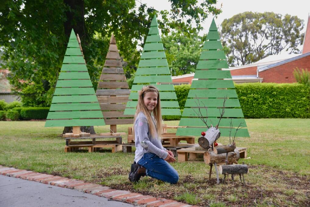 FORESTRY: Sydney Orwin plays with reindeer in Netherby's Christmas tree farm in Buninyong. Netherby is open this weekend.