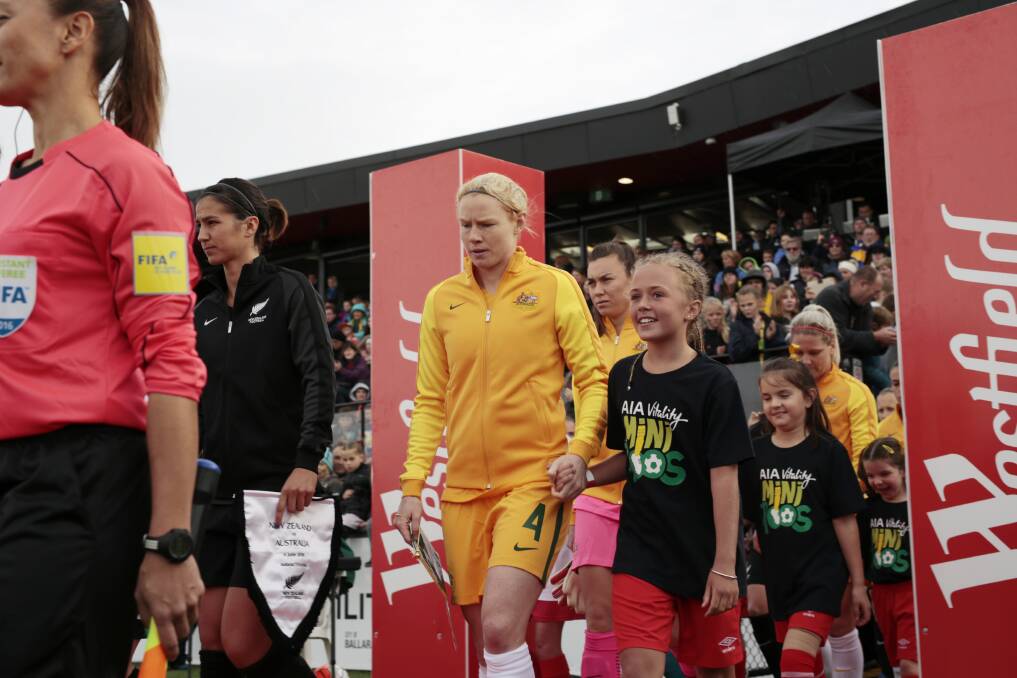 PATHWAY: Matildas- then-captain Clare Polkinghorne leads the team into action with MiniRoos, girls who will be on the cusp of pursuing the game's highest levels by 2023.