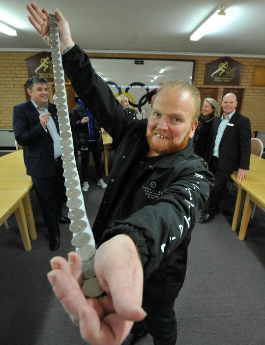 LINING UP: Campaign organiser Shane Darroch starts the world record mission with one metre of coins to help support cancer patients. Picture: Lachlan Bence