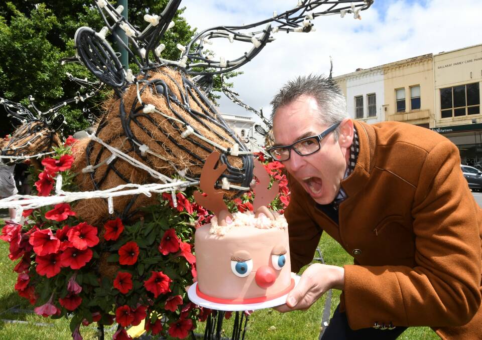 CELEBRATE: City of Ballarat mayor Ben Taylor gets ready to take a bite out of reindeer cake with one of the stars of Sturt Street each Christmas. The floral reindeer and celebrating their 10th birthday. Picture: Lachlan Bence.