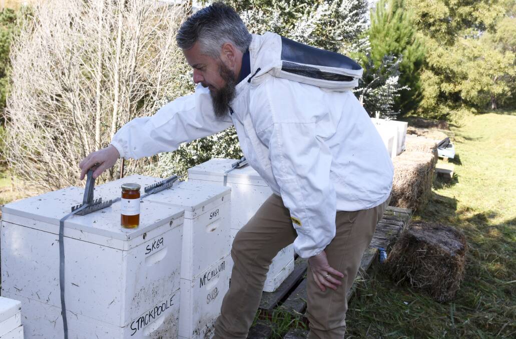 CHECK: Hives are closed for cooler months but Sovereign Hill operations manager Jarrod Page has jar of honey harvested to sell. Picture: Lachlan Bence