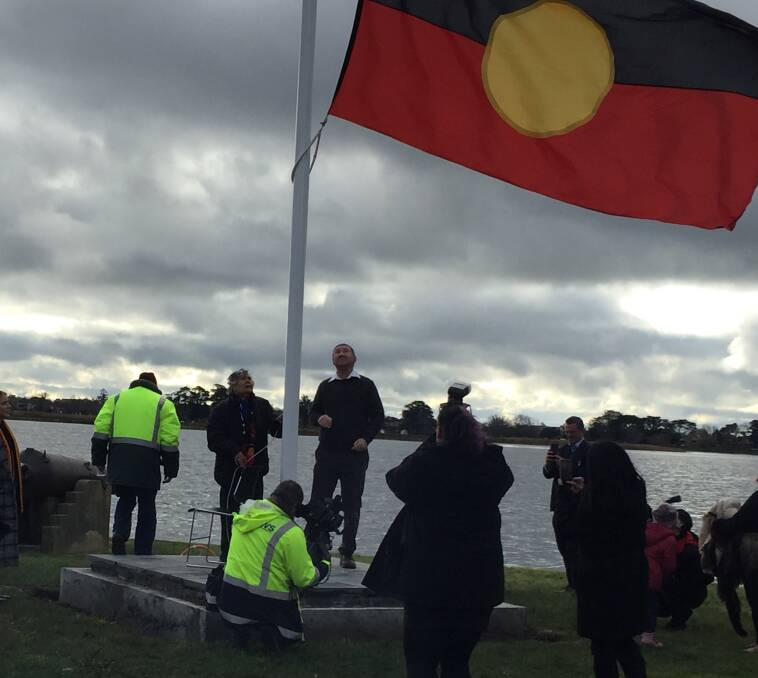 Aunty Diana Nickleson raises the Aboriginal flag at Lake Wendouree for the first time in more than 20 years. 