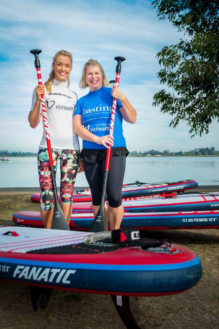 OUTDOOR FUN: Television presenter Brodie Harper prepares Kylie Wilson for an introductory stand-up paddleboarding session at Lake Wendouree. Picture: Dylan Burns