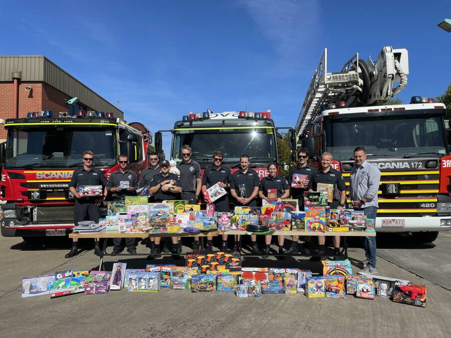 HELP: Fire Rescue Victoria members from Ballarat City and Lucas brigades offer up their carefully chosen toys to 3BA Christmas Appeal director John FitzGibbon on Thursday morning.