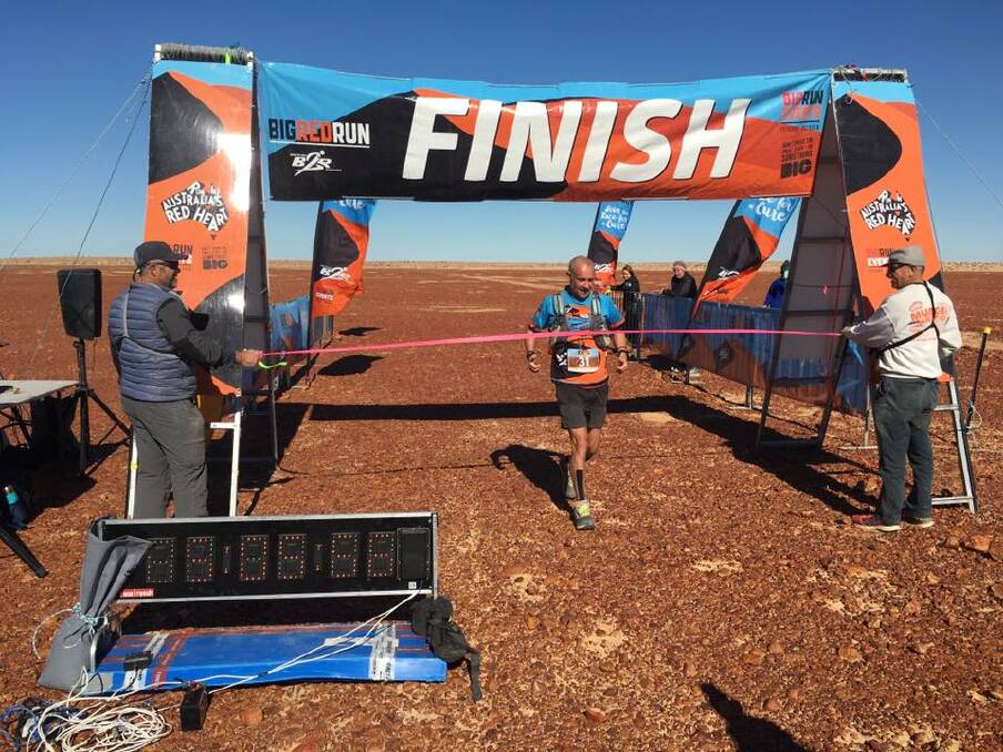 STEP ONE: Adventure runner Mick Marshall crosses the finish in the Simpson Desert. He turns his attention to Peru. Picture: Big Red Run, Facebook.