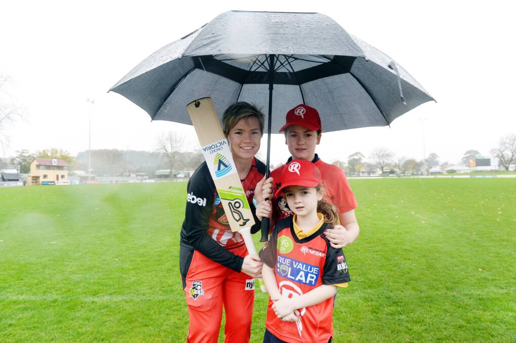PREPARE: Melbourne Renegade with junior Ballarat fans Georgia, age 7, and Grace Collier, 11, show the rain is again no worries when Big Bash comes back to town. Picture: Kate Healy
