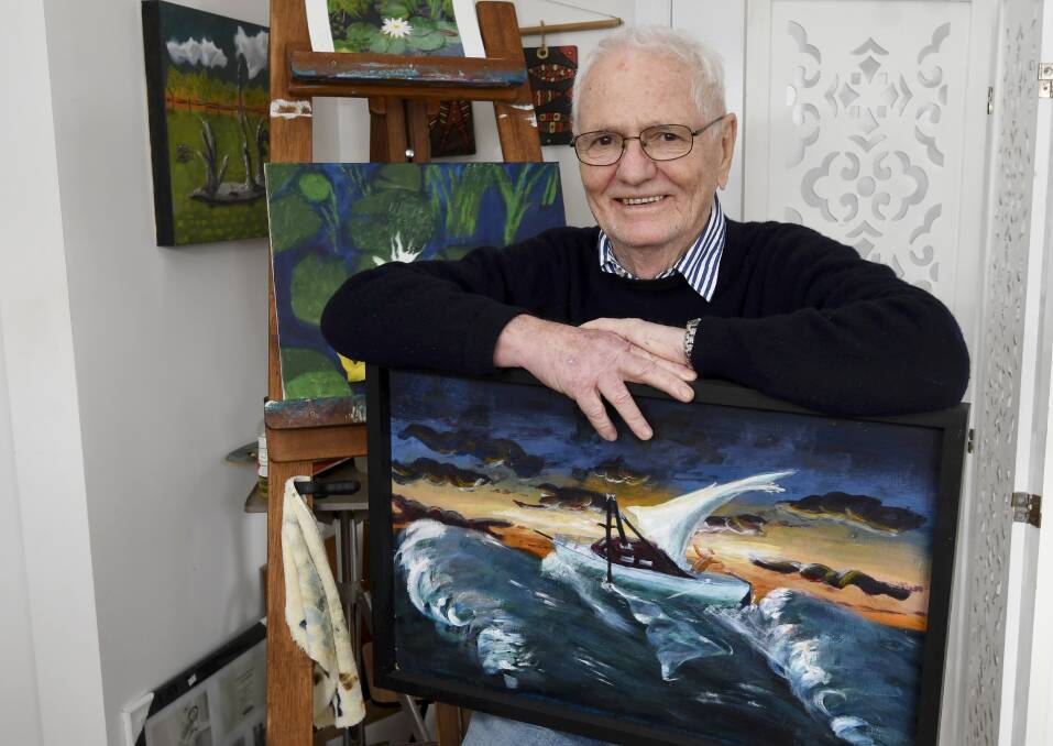 Artist John Sullivan with his painting of a ship with a broken mast in a storm, representing one of his divorces, and part of his autobiographical works. Picture by Lachlan Bence