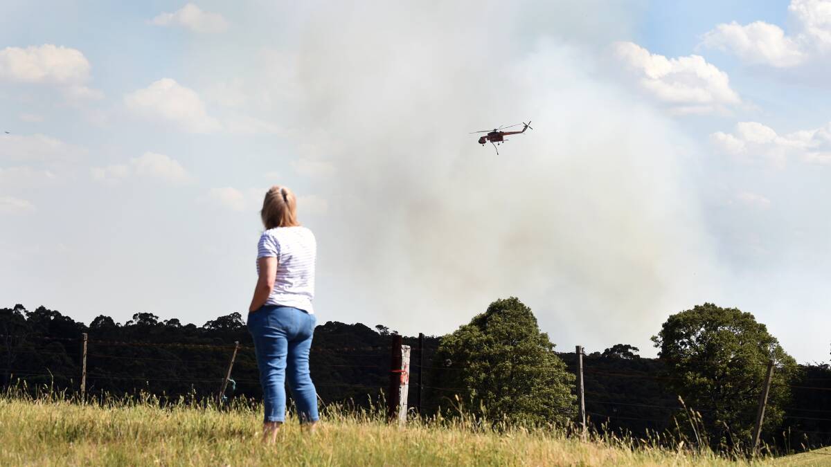 HAZE: A woman is left to watch her family home from the highway. Picture: Kate Healy