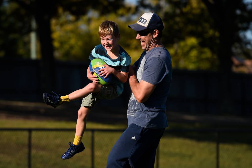 EXEFCISE: Seven-year-old Ethan has a kick of footy with his dad Andrew Mayne at City Oval. Picture: Adam Trafford