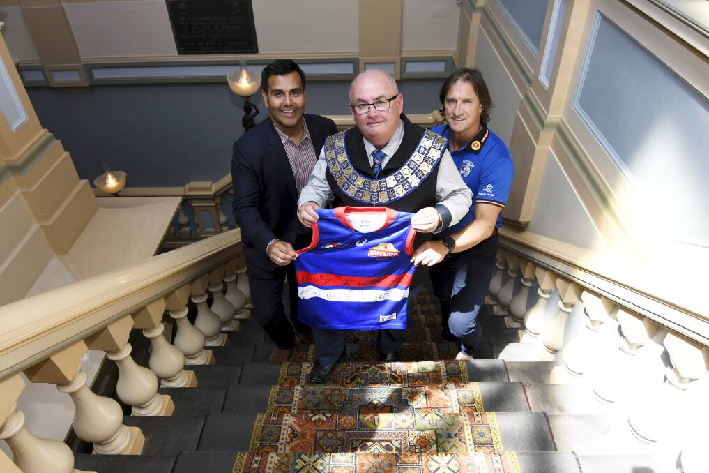 Western Bulldogs chief executive Ameet Bains and coach Luke Beveridge present City of Ballarat mayor Des Hudson with a signed guernsey at Ballarat Town Hall. Picture by Lachlan Bence