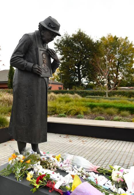 Floral tributes at the feet of the Grieving Mother statue in 2019. Picture by Adam Trafford