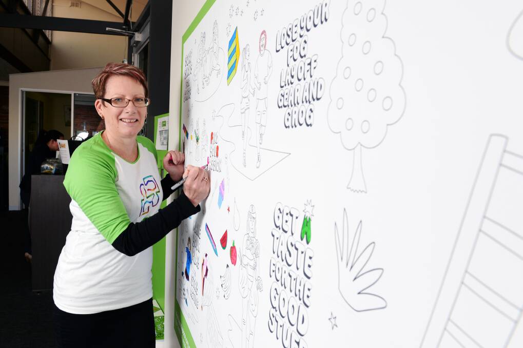 FIND YOUR COLOUR: A mindful mural is open for Ballarat's young people to make their mark and pick up tips for a healthier headspace as headspace Ballarat Janelle Johnson shows. Picture: Kate Healy