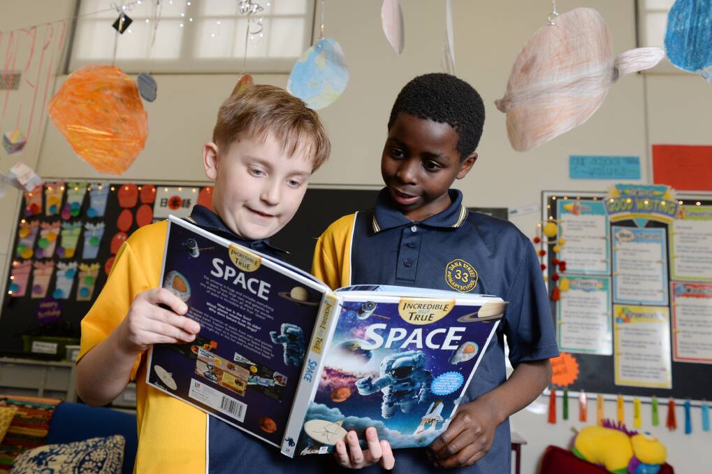 EXPLORING: Dana Street pupils Rhys and Izak take a closer look at astronauts and the moon in their inquiry classes this week. Picture: Kate Healy