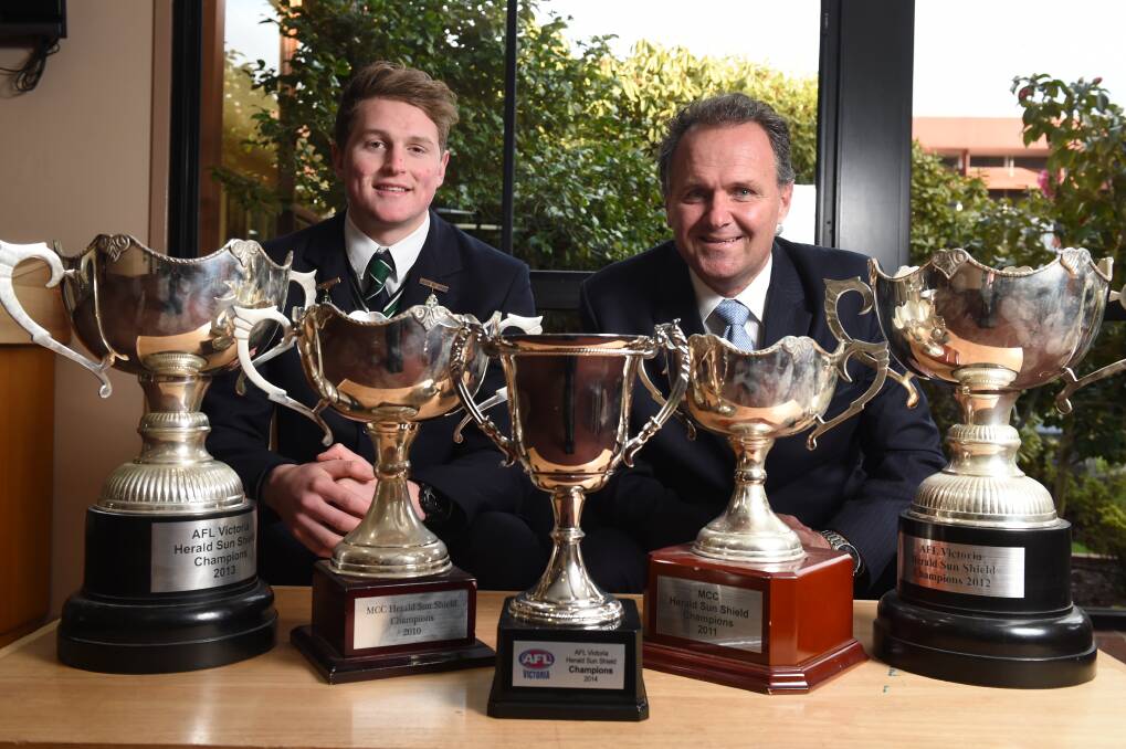 St Patrick's College football captain Jacob Hopper and coach Howard Clark with a glimpse of the school's football dynasty ahead of the 2015 Sun Shield grand final.