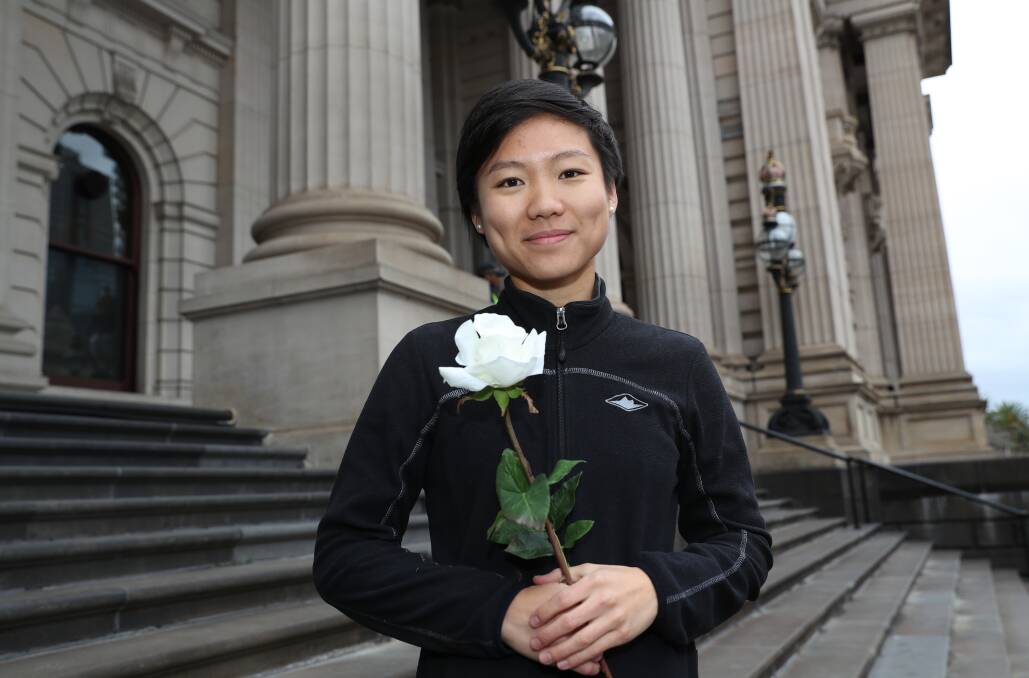 MISSION: Perth woman Belinda Teh pauses on the steps at Victorian Parliament House, holding a white rose for her mum, in a symbolic move to spark greater national talk and awareness on assisted dying. Picture: AAP