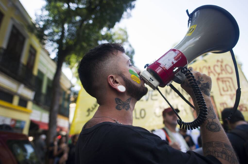 SPEAKING UP: A man with his face painted with green and yellow shouts with a megaphone during a protest against President Jair Bolsonaro's government, including fires in the Amazon rainforest, during a military parade commemorating Brazil's Independence Day, on September 7 in Rio de Janeiro. Picture: Getty Images