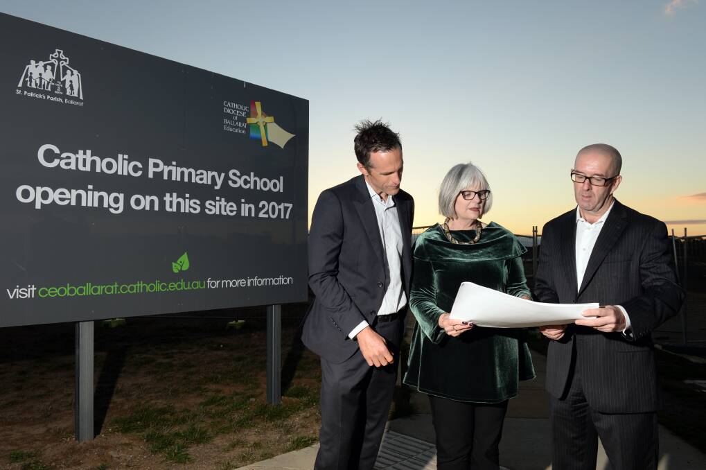 VISION: Catholic Education Office's Brad Carr, incoming principal Jo Brewer and Father Justin Driscoll look at plans for the new school on site. Picture: Kate Healy
