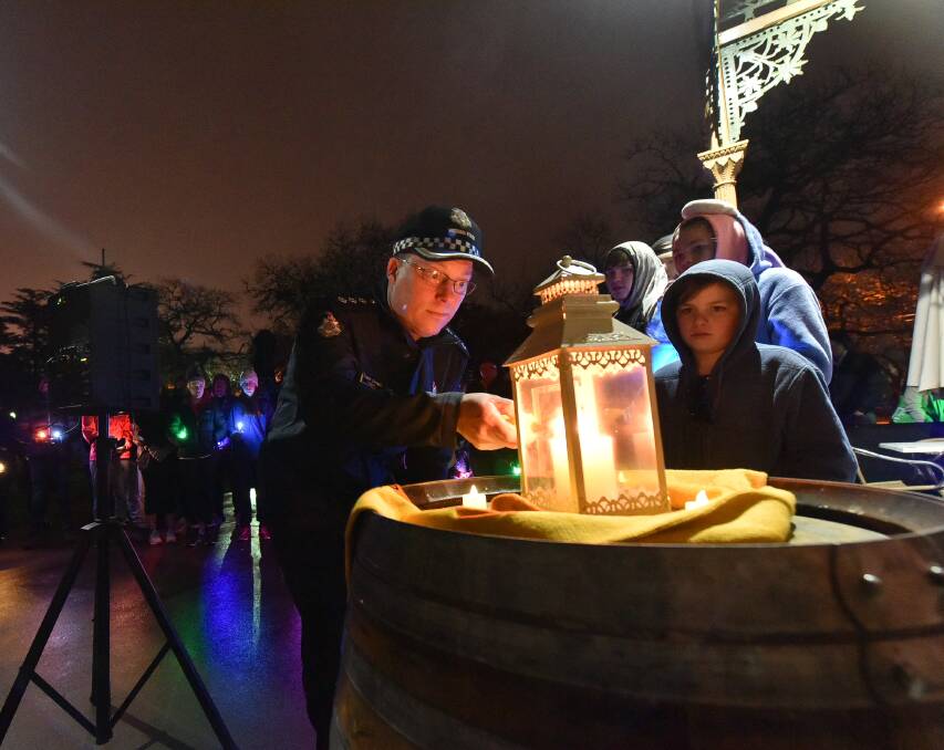 REFLECTION: Inspector Trevor Cornwill lights a candle in a sign of support and hope in the annual Out of the Shadows walk in Ballarat.