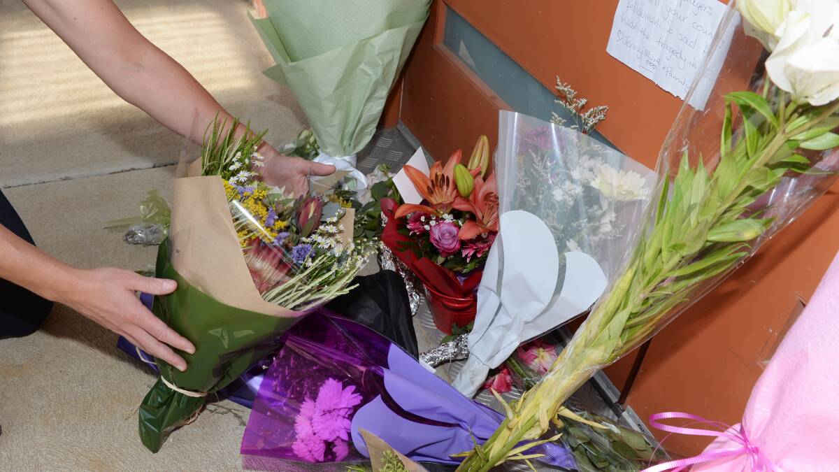 A woman lays a bouquet of flowers by the doors of the Ballarat mosque on Saturday. Picture: Kate Healy 