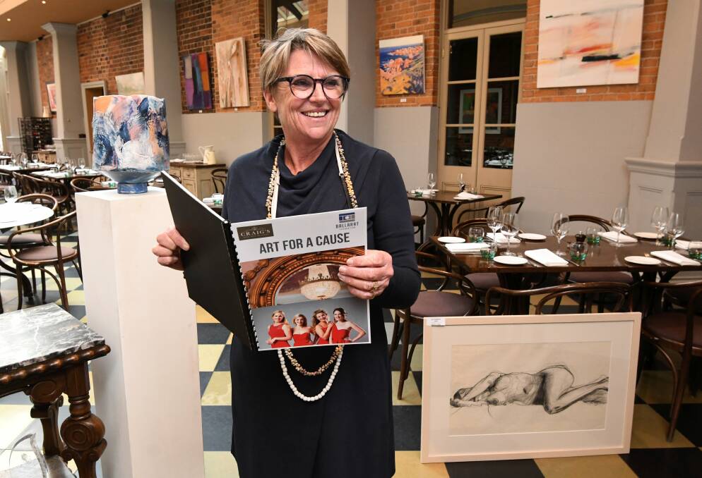 PERUSING: The Ballarat Foundation's Margo Pettit explores the catalogue of high-end art on offer in Art for a Cause. Picture: Lachlan Bence