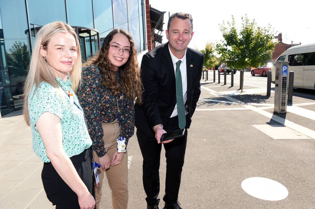 FOCUS: Ballarat Health Services' people and culture executive director Claire Woods with Deakin medical student Katerina Lau and City of Ballarat mayor Daniel Moloney check in safe via a footpath QR code. Picture: Kate Healy