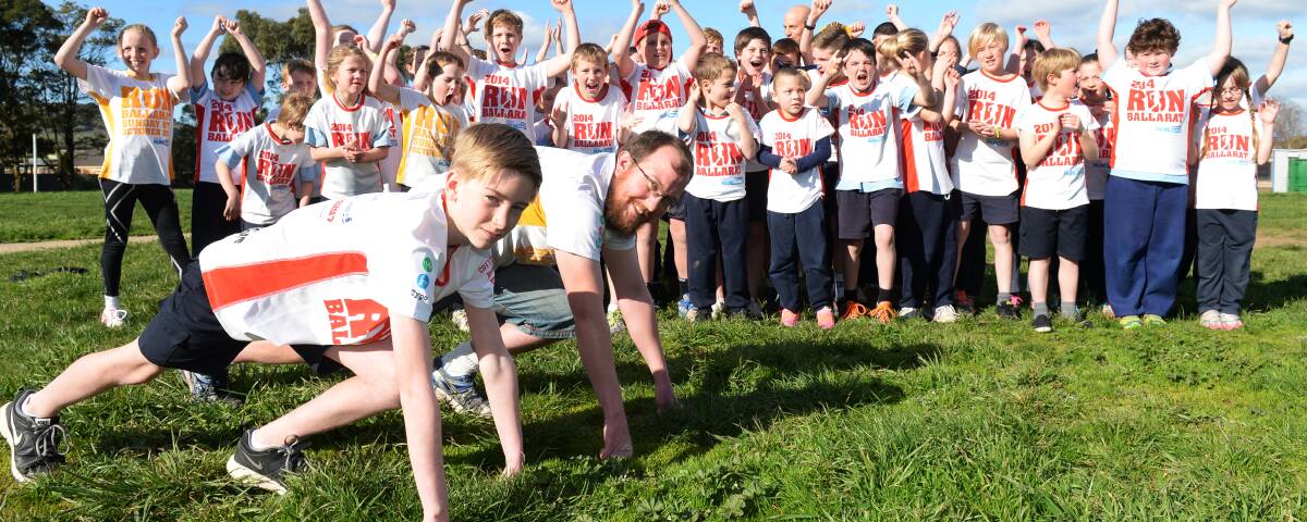SUPPORT: Jack and teacher Ben Mitchell help Miners Rest get set for Run Ballarat last year, setting a sporting example for their extended school community. Picture: Kate Healy