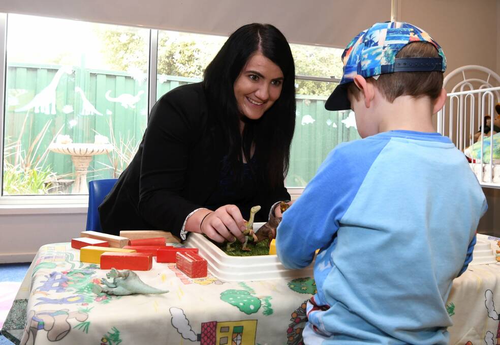 CARE: SalvoConnect Western children's support worker Chantelle Cutler works play dinosaurs with a young child this week. Picture: Lachlan Bence
