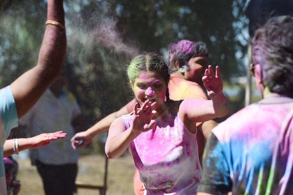 COLOUR POP: Anna Elangovan dances through a shower of bright powder amid Ballarat Holi celebrations on Sunday. Picture: Kate Healy
