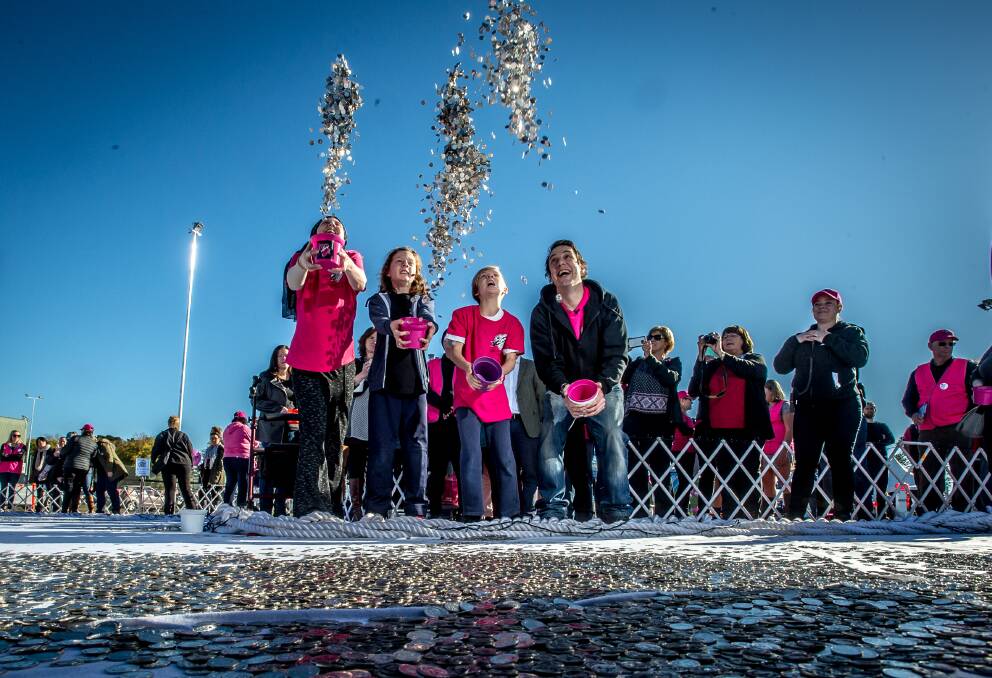CREATING CHANGE: Samuel Johnson, his big sister Connie and her sons, throw streams of five-cent coins into a heart-shaped silver lake worth more than $2 million to fight cancer in May 2017. Picture: Canberra Times