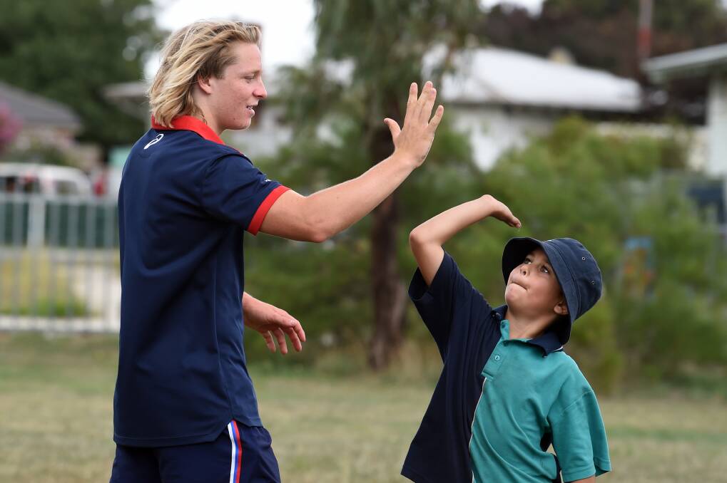 PARTNERSHIP: Western Bulldogs' top draft pick Cody Weightman celebrates a school visit with Yuille Park grade three pupil DJ in Ballarat earlier this week. Picture: Kate Healy