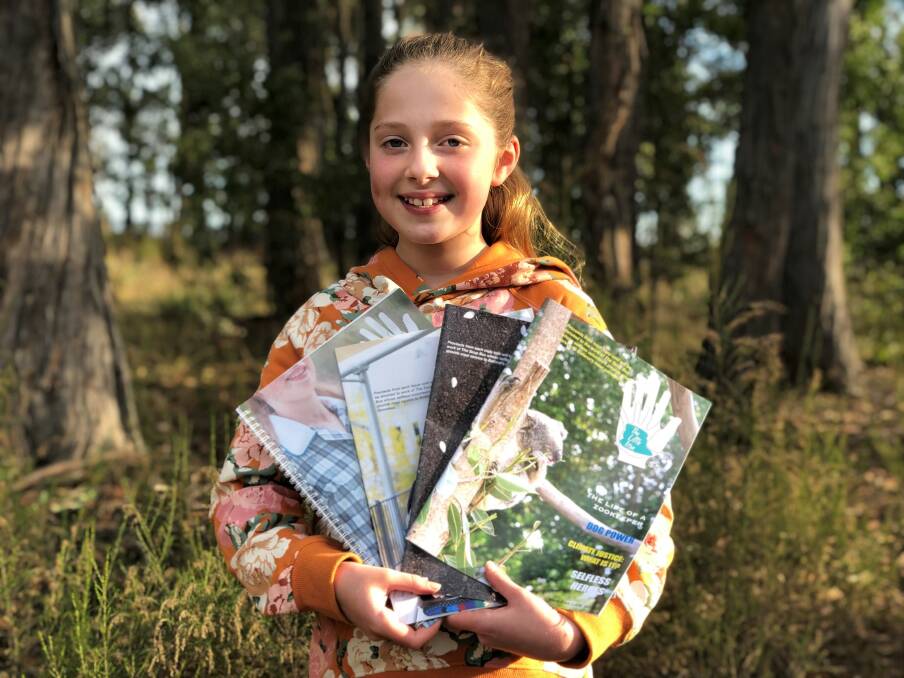 Matilda with past editions of The Little Issue. Picture courtesy of Fred Hollows Foundation.