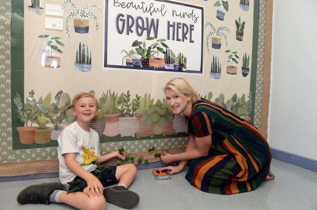 Graduate teacher Julia McGregor gets a helping hand from an expert, her son Angus, in setting up her classroom. Picture by Kate Healy