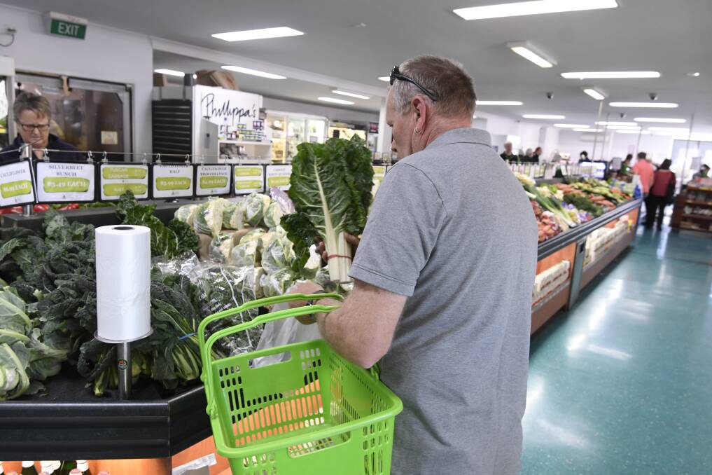 PREPARING: A shopper ensures they get their fresh greens at Wilson's Fruit and Vegetables this week. Picture: Lachlan Bence