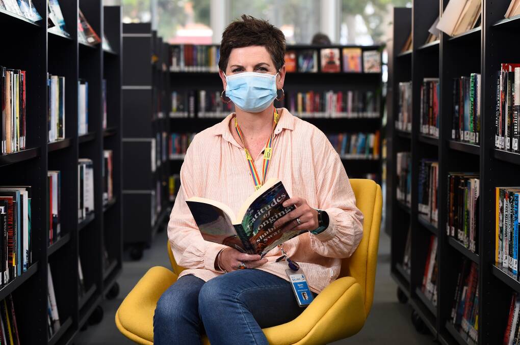 OPEN BOOK: Ballarat Libraries' Narelle Cooney gets stuck into a new read as people start safely returning to browse. Picture: Adam Trafford
