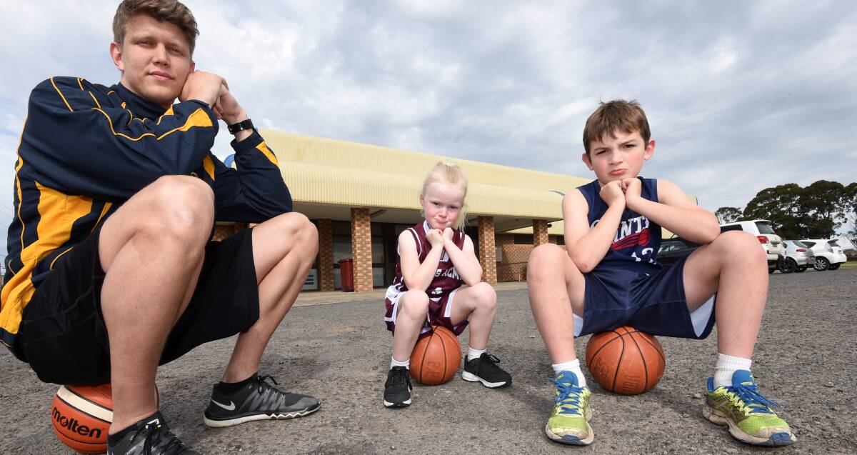 LEFT IN COLD: Ballarat Miner Chris Smith with basketball juniors Lilli Clark and Jacob Hutchinson outside the delapidated Wendouree stadium. Picture: Lachlan Bence