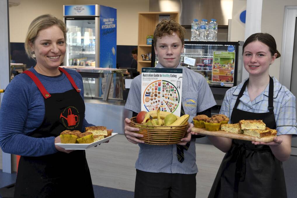 PLATING UP: Mount Roan food technology assistant Chloe Hewitt serves up the new canteen menu with students Adam Locke and Courtney Dwyer. Picture: Lachlan Bence