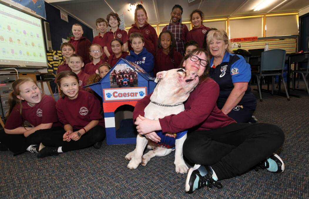 Puppy love: Western Bulldogs' mascot Caesar thanks Cynthia and her Wendouree primary classmates for a specially made kennel. Picture: Lachlan Bence