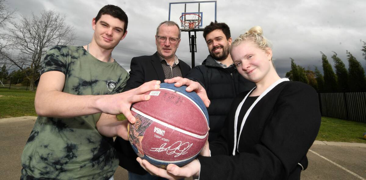 TIP-OFF: Ballarat Specialist School students Darcy King and Rachael Lubcke get their hands on the ball with Midlands chairman Darren Bandy and teacher Mat Gannon. Picture: Lachlan Bence