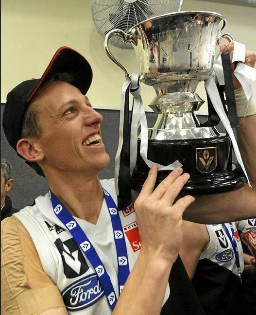 GLORY: Inspirational captain Shaune Moloney with the Roosters' third Victorian Football League premiership cup. 